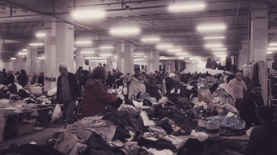 Indoor market hall with tables of clothing — where sorted lots like ours are resold