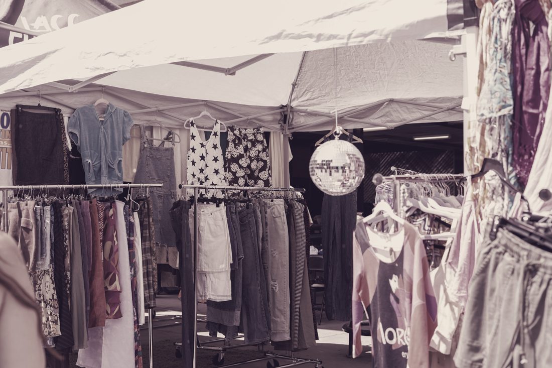 Market stall with shirts, trousers and jackets under a canopy
